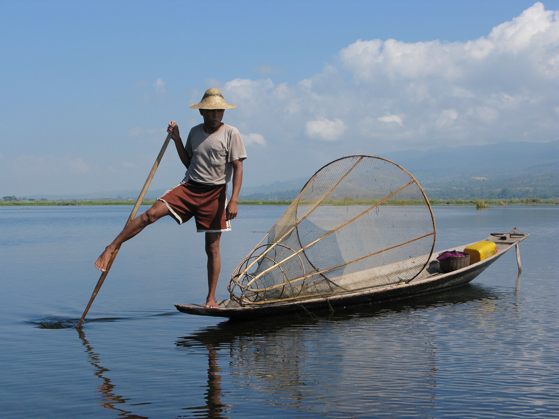 An Intha fisherman demonstrating the traditional leg-rowing technique, a skill passed down through generations.