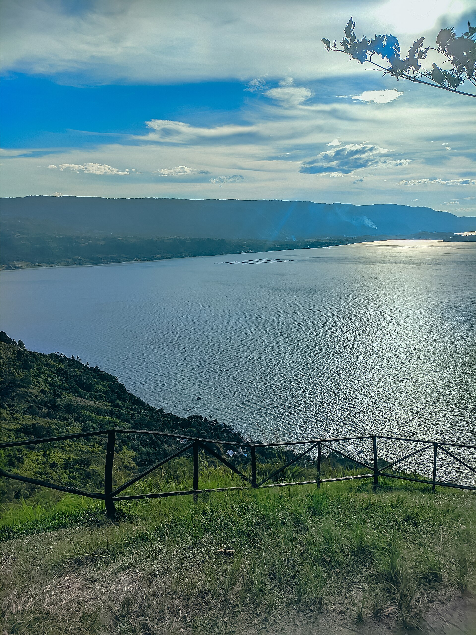 A stunning viewpoint overlooking the expansive Lake Toba and its surrounding hills.