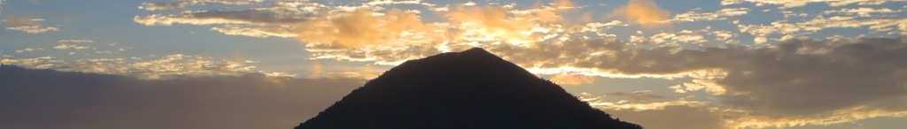 A breathtaking sunset casts a warm glow over the volcanic peaks of Banda Neira.